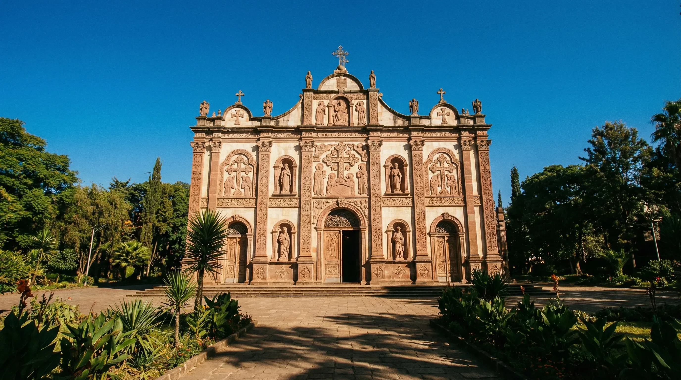 The ornate stone facade of the Holy Trinity Cathedral in Addis Ababa, Ethiopia, under a clear blue sky.